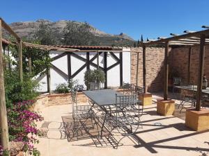 a patio with a table and chairs under a pergola at Cortijo Ramonsillos in Villanueva del Trabuco