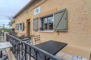 a building with a table and chairs on a balcony at Maison Loustalet in Arzacq-Arraziguet