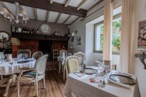 a dining room with tables and chairs and a fireplace at Maison Loustalet in Arzacq-Arraziguet