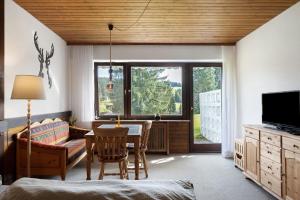 a living room with a table and a television at Appartment Auszeit in Schönwald