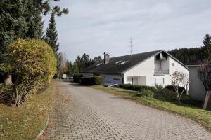 a cobblestone road in front of a white house at Appartment Auszeit in Schönwald