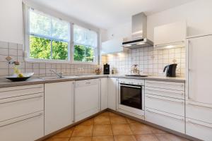 eine Küche mit weißen Schränken und einem Fenster in der Unterkunft Budererhof in Freiamt