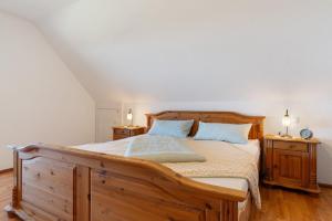 ein Schlafzimmer mit einem Holzbett und blauen Kissen in der Unterkunft Budererhof in Freiamt
