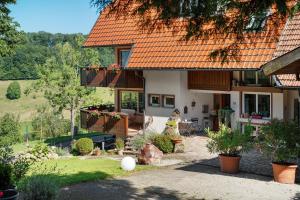 ein Haus mit einem orangefarbenen Dach und einem Garten in der Unterkunft Budererhof in Freiamt