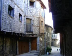an alley in an old stone building with a door at Casa Lopez San Martín in San Martín del Castañar