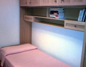 a room with a bed and a shelf with books at Casa Lopez San Martín in San Martín del Castañar