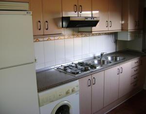 a kitchen with a sink and a stove at Casa Lopez San Martín in San Martín del Castañar
