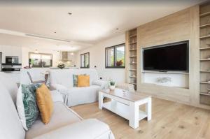 a living room with white furniture and a flat screen tv at Villa Ona in Port de Soller