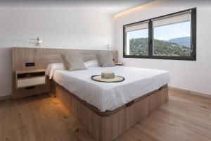 a bedroom with a large bed with a large window at Villa Ona in Port de Soller +26 photos