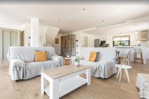 a living room with two white couches and a table at Villa Ona in Port de Soller