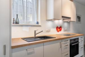 a kitchen with white cabinets and a sink at Im Rosengarten 2 in Zell am Harmersbach