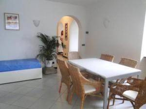 a dining room with a table and chairs and a bed at Apartment CASA SPIAGGIA by Interhome in Castelletto di Brenzone