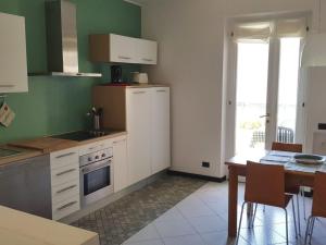 a kitchen with white cabinets and a table and a window at Apartment CASA SPIAGGIA by Interhome in Castelletto di Brenzone +7 photos