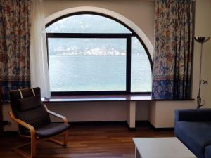 a living room with a large window with a view of the ocean at Apartment CASA SPIAGGIA by Interhome in Castelletto di Brenzone