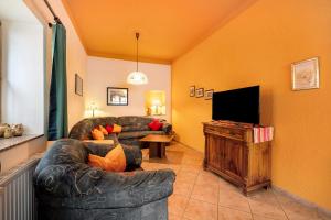 a living room with a couch and a flat screen tv at Eulennest 1 in Minheim