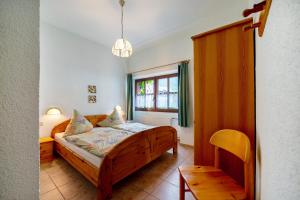 a bedroom with a wooden bed and a window at Eulennest 1 in Minheim