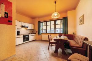 a living room with a table and a kitchen at Eulennest 1 in Minheim