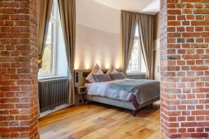 ein Schlafzimmer mit einem Bett und zwei Fenstern in der Unterkunft Café Wasserturm Cuxhaven in Cuxhaven