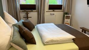 a bedroom with a bed with pillows and a cross at Reni's 4 Sterne Ferienwohnung in Leverkusen