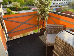a balcony with an orange gate and a potted plant at Reni's 4 Sterne Ferienwohnung in Leverkusen