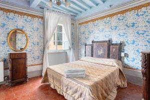 a bedroom with blue wallpaper and a bed with a mirror at Villa Chelucci - Gualdo in Massarosa +195 photos