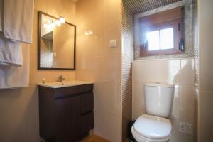 a bathroom with a toilet and a sink and a window at Casa do Avô - Alojamento Sortelha in Sortelha +6 photos
