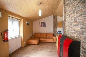 a living room with a couch and a brick wall at Casa do Avô - Alojamento Sortelha in Sortelha