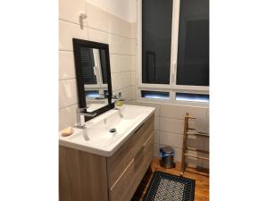 a bathroom with a sink and a mirror at Rayon de soleil Arcachon in Arcachon