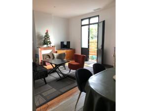 a living room with a table and chairs and a christmas tree at Rayon de soleil Arcachon in Arcachon