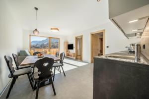 a kitchen and dining room with a table and chairs at Sunnig Apartment Abendsonne in Vollan