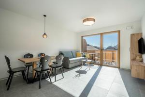 a living room with a couch and a table and chairs at Sunnig Apartment Abendsonne in Vollan