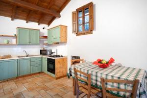 a kitchen with green cabinets and a table with chairs at Casa Verde - Sciu´ Pepin in Rezzo