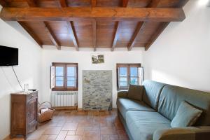 a living room with a couch and a tv at Casa Verde - Sciu´ Pepin in Rezzo