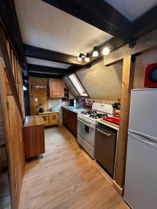 a kitchen with a stove and a refrigerator at Red Sleigh Chalet - Campton in Campton