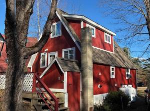 a red barn with a chimney at Red Sleigh Chalet - Campton in Campton