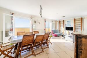 a kitchen and living room with a table and chairs at Logement vue mer à 50m de plage in Barbâtre +15 photos