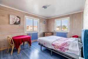 a bedroom with a bed and a table and chairs at Logement vue mer à 50m de plage in Barbâtre