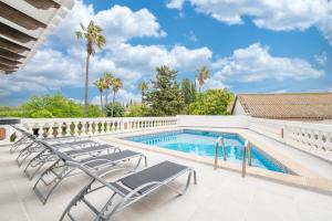 a swimming pool with lounge chairs and palm trees at Moli dels Reis in Palma de Mallorca