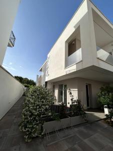 a large white building with flowers in front of it at Lungomare Santa Caterina in Nardò