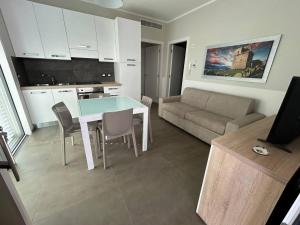 a kitchen and living room with a table and a couch at Lungomare Santa Caterina in Nardò