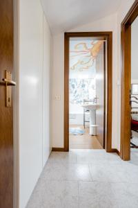 a hallway with a door with a painting on the wall at Suite Al Pian Apartment in I Gugi