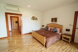 a bedroom with a large bed and a wooden floor at Trivista Khaoyai in Ban Khanong Phra Klang (1)