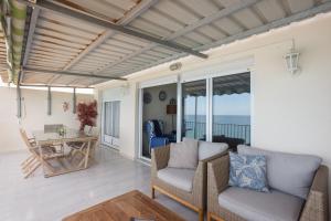 a living room with chairs and a table with a view of the ocean at Flamingo in Tavernes de Valldigna
