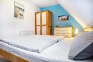 a bedroom with a white bed and a dresser at Kranich in Pruchten