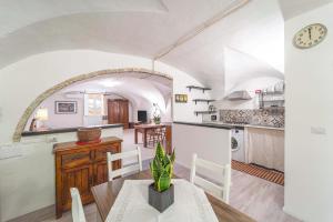 a kitchen and living room with a table and a clock at Casa Gilbert 101 in Alghero