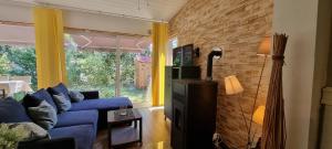 a living room with a blue couch and a brick wall at Ferienhaus Haffschatz in Ueckermünde