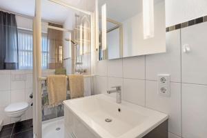 a white bathroom with a sink and a toilet at Ferienwohnung Riedel in Sundern +27 photos