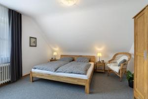 a bedroom with a bed and a chair at Ferienwohnung Riedel in Sundern