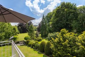 a garden with bushes and trees and an umbrella at Ferienwohnung Riedel in Sundern