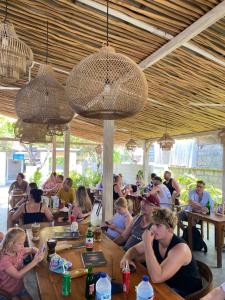 a group of people sitting at tables in a restaurant at Danys House at Tiki Bar and More in Nusa Lembongan